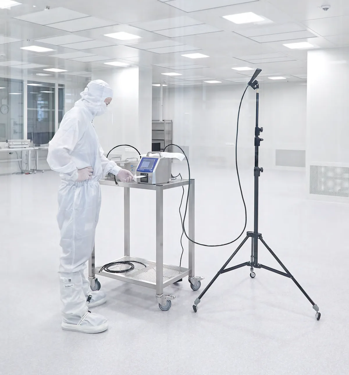 Techniker in Reinraumkleidung bei der Messung in einem Reinraum